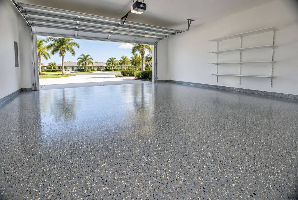 A dark garage with a high-gloss charcoal and copper metallic epoxy floor reflecting the ceiling lights